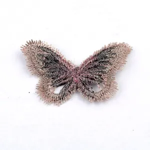 Primer plano detallado de un parche bordado de mariposa en oro rosa metálico para DIY