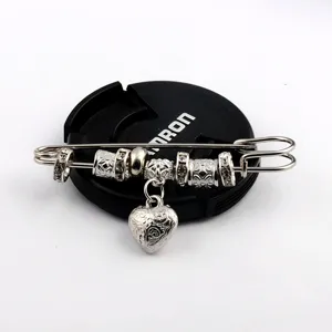 Vintage silver safety pin shawl brooch with decorative beads and a detailed heart pendant