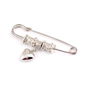 Vintage silver safety pin brooch featuring a heart pendant for shawls and sweaters.
