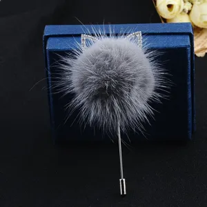 Nahaufnahme einer grauen Nerzfell-Pompon-Brosche mit glitzernden Strass-Katzenohren