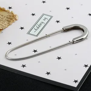 Detailed view of a large silver metal safety pin brooch for cardigans and scarves