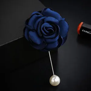 Macro view of handmade blue fabric flower lapel pin with a long silver needle and pearl
