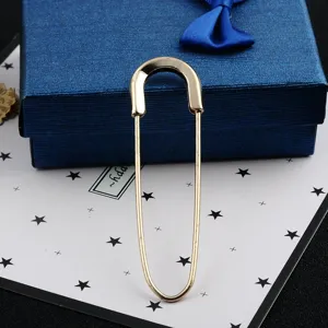 Detailed close-up of a large minimalist gold-toned safety pin brooch for scarves