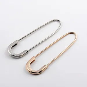 Detailed macro view of stylish large safety pin brooches in silver and rose gold tones