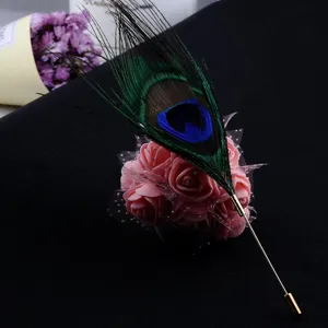 Detailed macro view of peacock feather brooch pin featuring pink roses and mesh
