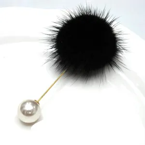 Detailansicht einer eleganten Brosche aus schwarzem Nerzfell mit einer weißen Perle
