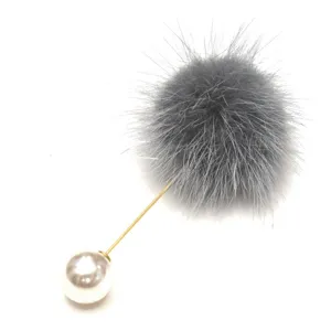 Makroansicht der grauen Nerzfell-Pompon und der weißen Perle der Brosche