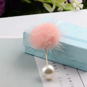 Detailansicht einer rosa Nerzpelz-Brosche mit einer großen weißen Perle an einer Nadel