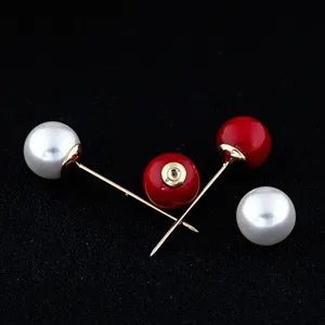 Makro-Detail von eleganten Doppelperlen-Anstecknadeln in Rot und Weiß für Pullover