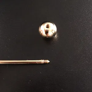 Close-up of the screw attachment on a gold-tone metallic brooch pin