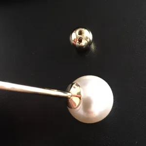 Close-up of elegant double-headed pearl brooch showing the gold screw ball mechanism
