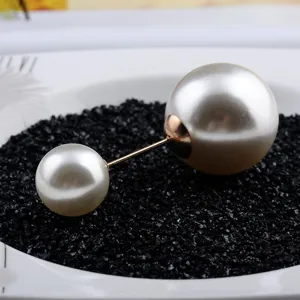 Detailaufnahme einer eleganten doppelten Perlenbrosche auf dekorativem Hintergrund.