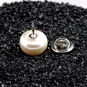 Detailansicht einer Anstecknadel mit Kunstperle und silbernem Schmetterlingsverschluss