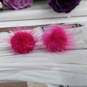 Nahaufnahme der flauschigen rosa Nerzpelz-Pom-Pom-Ohrstecker für den Winter
