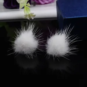 Nahaufnahme von weißen Nerzpelz-Ohrringen für den Winter, elegantes Schmuckdetail