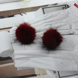 Detailansicht der weinroten Nerzfell-Pompon-Ohrringe mit feinen schwarzen Spitzen