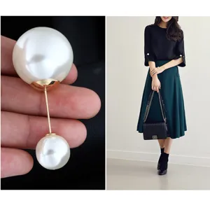 Elegante doppelköpfige weiße Perlenbrosche in Makrodetails und Model-Outfit-Styling