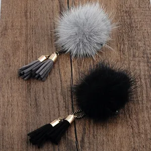 Detailaufnahme von grauen und schwarzen Nerzfell-Pompon-Broschen mit Zierquasten