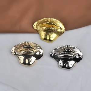 Detailed view of three vintage 3D lip-shaped brooches in gold and silver metallic finishes