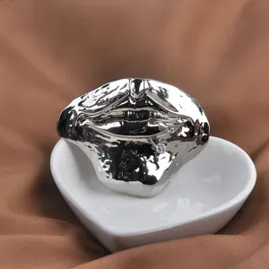 Close-up of a silver vintage 3D lip brooch with unique melting texture and crystal accents.