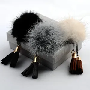 Nahaufnahme von Nerzfell-Pompon-Broschen mit Wildlederquasten in drei Farben.