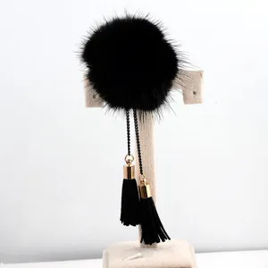Detailansicht einer schwarzen Nerzpelz-Pompon-Brosche mit eleganten Quasten.