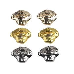 Detail view of exaggerated lip brooches in gold and silver finishes with rhinestones