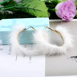 Primer plano que muestra la textura esponjosa de la piel de visón blanco en los aros.