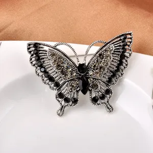 Makrodetail einer Vintage-Schmetterlingsbrosche mit schwarzen und klaren Steinen