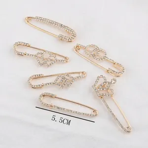 Nahaufnahme von vergoldeten Sicherheitsnadel-Brosche mit Strass und Kronen-Design