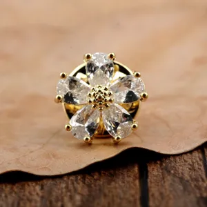 Detailansicht einer goldfarbenen Brosche in Form einer Blume mit klaren Zirkonias.