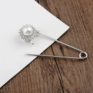 Detailaufnahme einer silbernen Sicherheitsnadel-Brosche mit Perlen-Sonnenblumen-Design