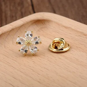 Detail einer Mini-Blumenbrosche mit fünf klaren Zirkonia-Blütenblättern in Goldfassung