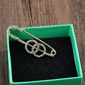 Detailansicht einer eleganten goldfarbenen Strass-Sicherheitsnadel in Geschenkbox