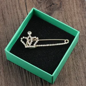 Detailansicht einer eleganten goldenen Kronen-Sicherheitsnadel-Brosche mit Strasssteinen