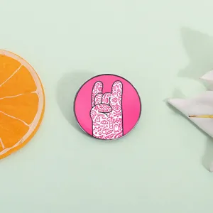 Fun hand-drawn doodle rock gesture metal pin on a refreshing mint green background