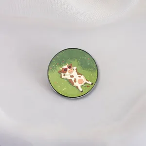 Cute cartoon cow wearing sunglasses lying on grass round metal enamel pin badge accessory