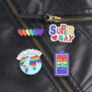 Detailed view of four rainbow Pride enamel pins pinned to a textured black leather jacket.