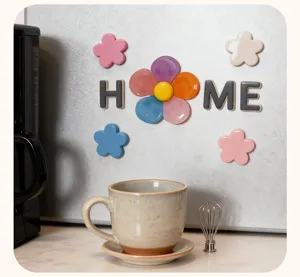 Close-up of colorful floral magnetic clips spelling home on a clean metallic kitchen fridge surface.