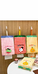 Hanging fabric tissue holder with cute cartoon prints, wall-mounted storage bag for home use.