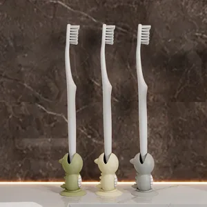 Simpatico set porta spazzolino dinosauro con supporto a ventosa e setole morbide.