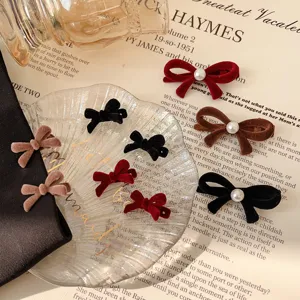 Velvet bow hair clips with pearls in red black and brown on vintage background