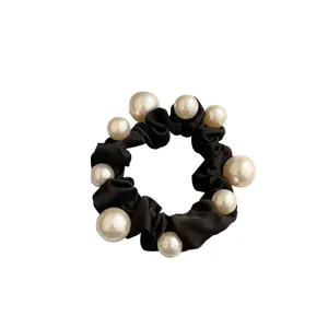 Elegante elastico per capelli in tessuto nero con perle finte bianche di varie misure.