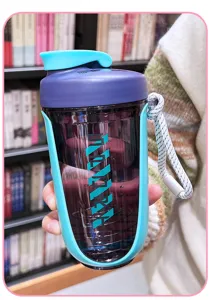 Plastic shaker bottle with large capacity, mixing ball and portable lanyard for sports fitness.