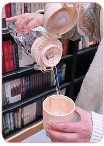 Süße Kunststoff-Wasserflasche mit Tragegurt und doppeltem Trinkdesign für den Alltag.