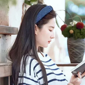 Close-up side view of an Asian model wearing a blue knotted denim style headband