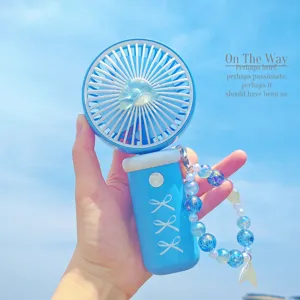 Mini ventilateur à main portable avec bracelet de perles et nœud pour un rafraîchissement idéal.