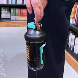 Bouteille d'eau shaker de sport en plastique portable avec couvercle et poignée sécurisées.