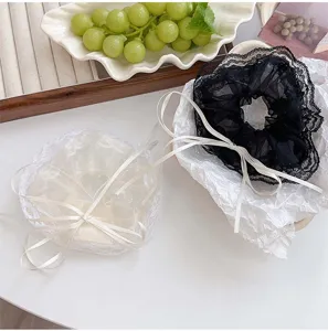 Détail de chouchous élégants en résille avec de longs nœuds en ruban noir et blanc