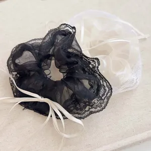 Vue détaillée des chouchous en maille avec bords en dentelle et nœuds en ruban chic.